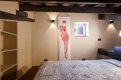 a bedroom with a bed and a painting of a woman at Loft Navona in Rome