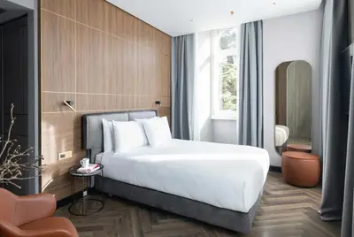 a bedroom with a large white bed and a chair at Palazzo 4 Fontane 12 in Rome