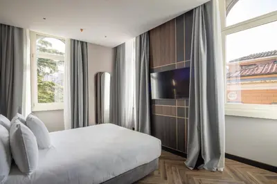a bedroom with a bed and a tv and a window at Palazzo 4 Fontane 12 in Rome