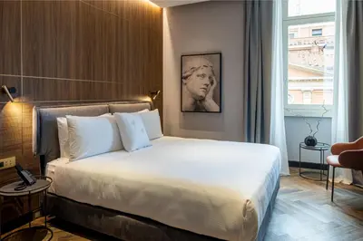 a bedroom with a large white bed in a room at Palazzo 4 Fontane 12 in Rome