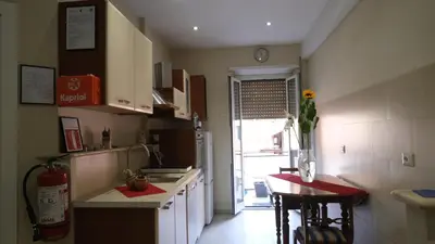 a kitchen with a sink and a table with chairs at B&B Caput Mundi in Rome