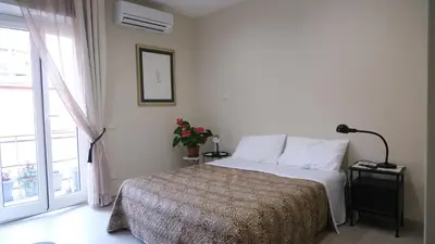 a white bedroom with a bed and a window at B&B Caput Mundi in Rome