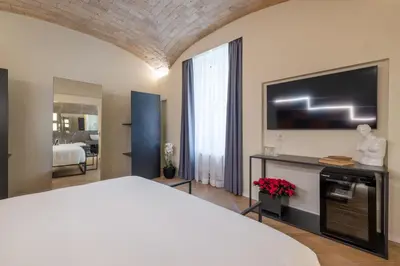 a bedroom with a bed and a flat screen tv at Scipioni 235 Luxury Suite in Rome