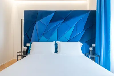 a bedroom with a blue headboard and a white bed at Scipioni 235 Luxury Suite in Rome