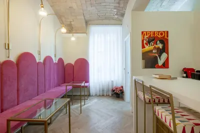 a row of pink booths in a room with tables and chairs at Scipioni 235 Luxury Suite in Rome
