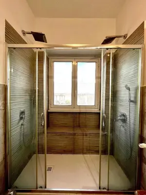 a glass shower in a bathroom with a window at San Pietro APT near Vatican city Roma in Rome