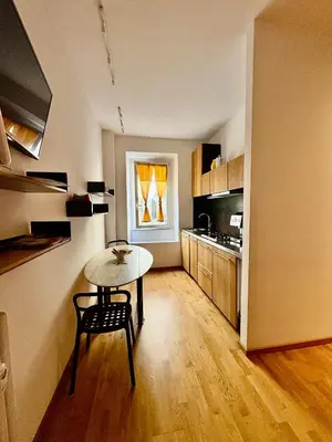 a small kitchen with a table and a dining room at Loft in Colosseum, style in the heart of Rome! in Rome