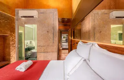 a bedroom with a large white bed with a bathroom at Locanda da Enzo in Rome