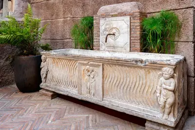 a stone fountain with a statue of a boy and a girl at Locanda da Enzo in Rome