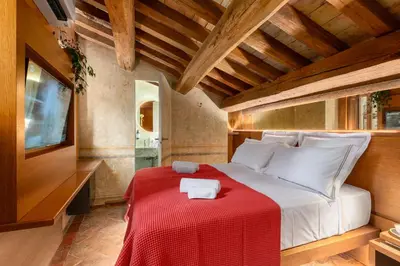 a bedroom with a large bed with a red blanket at Locanda da Enzo in Rome