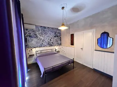 a bedroom with a bed and a painting on the wall at The Attic Penthouse Rome Cozy & Comfy Close to Trastevere & Center With WIFI in Rome