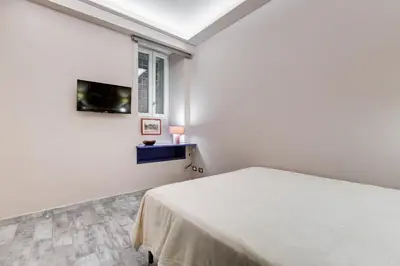 a white bedroom with a bed and a window at LuxurySistersHouse 2 min Colosseum in Rome