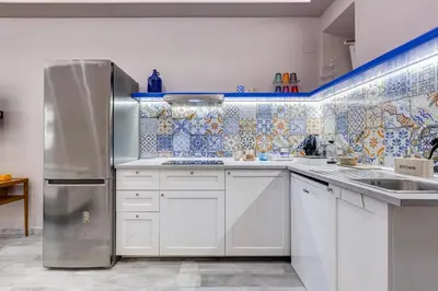 a kitchen with white cabinets and a stainless steel refrigerator at LuxurySistersHouse 2 min Colosseum in Rome