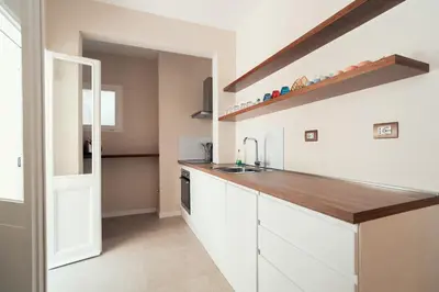a kitchen with white cabinets and a wooden counter top at Casa Mia Navona in Rome