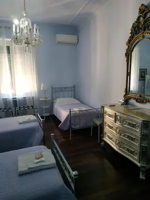 a bedroom with two beds and a mirror and a dresser at Around The Corner Colosseo B&B in Rome