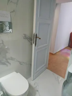 a bathroom with a white toilet and a door at Around The Corner Colosseo B&B in Rome