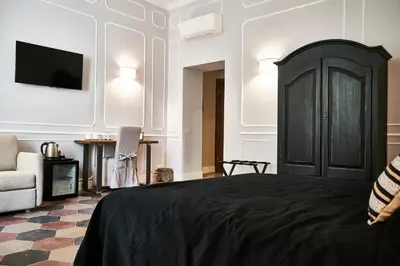 a bedroom with a black bed and a chair at Ale & Niki's Home in Rome