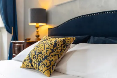 a bed with a black and gold pillow on it at RomanticRome, elegant apartment in Trastevere district in Rome