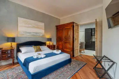 a bedroom with a king sized bed and a dresser at RomanticRome, elegant apartment in Trastevere district in Rome