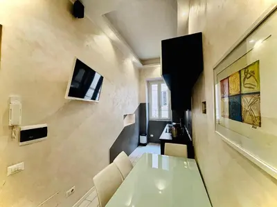 a dining room with a white table and chairs at Monti Hideaway - Walk to Colosseum & Forum in Rome