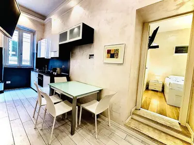 a kitchen with a table and chairs in a room at Monti Hideaway - Walk to Colosseum & Forum in Rome