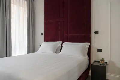 a bedroom with a large white bed with a red headboard at Casa Guttmann in Rome