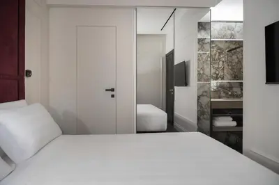 a bedroom with a white bed and a bathroom at Casa Guttmann in Rome