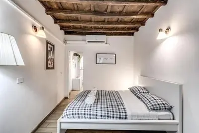 a bedroom with a bed and a wooden ceiling at Petite Fleur in Rome