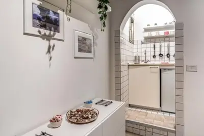 a white kitchen with a pizza on a counter at Petite Fleur in Rome