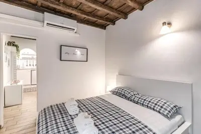 a bedroom with a bed in a white room at Petite Fleur in Rome