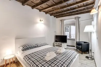 a bedroom with a bed and a television and a chair at Petite Fleur in Rome