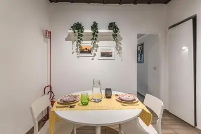 a dining room with a white table and chairs at Petite Fleur in Rome