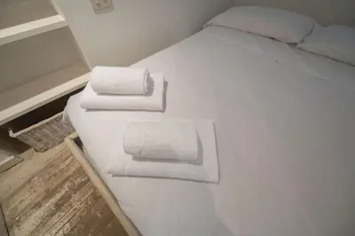 a white bed with two towels on top of it at Elegant Design Retreat by Campo de Fiori in Rome