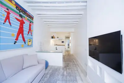 a living room with a white couch and a flat screen tv at Elegant Design Retreat by Campo de Fiori in Rome