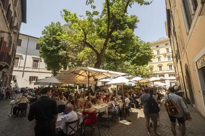 a group of people sitting at tables with umbrellas at Elegant Design Retreat by Campo de Fiori in Rome