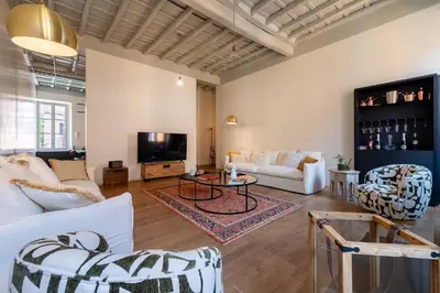 a living room with white furniture and a tv at Skylife Monti's Wonders - Colosseum Gem in Rome