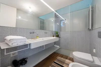 a white bathroom with a sink and a toilet at Skylife Monti's Wonders - Colosseum Gem in Rome