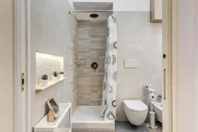 a white bathroom with a toilet and a shower at Loft in the Ghetto 2 in Rome