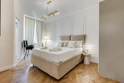 a white bedroom with a large bed and a desk at Vatican Design Apartment - NEW! in Rome