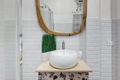 a bathroom with a white sink and a mirror at Vatican Design Apartment - NEW! in Rome