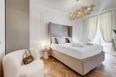 a white bedroom with a large bed and a chair at Vatican Design Apartment - NEW! in Rome