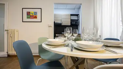 a dining room with a table with chairs and wine glasses at Flat 5 - In San Giovanni by Rentbeat in Rome