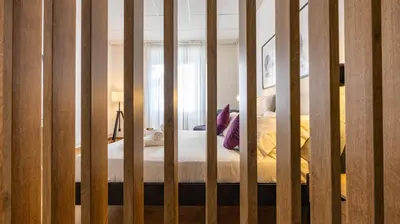 ajar view of a bed in a room at Flat 5 - In San Giovanni by Rentbeat in Rome