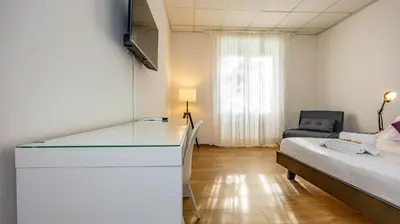 a room with a bed and a desk in a room at Flat 5 - In San Giovanni by Rentbeat in Rome