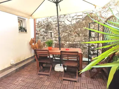 a table and chairs with an umbrella on a patio at Piramide Charming Flat e Terrace in Rome