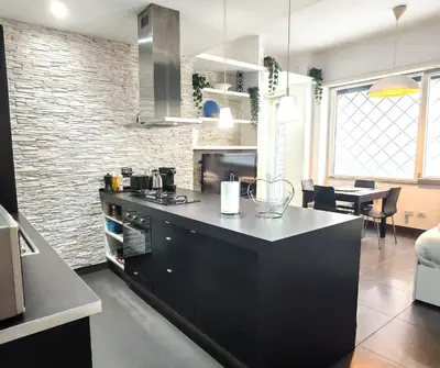 a kitchen with a black island in a room at Piramide Charming Flat e Terrace in Rome