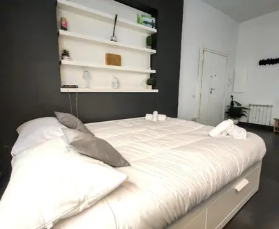 a large bed with white sheets and pillows on it at Piramide Charming Flat e Terrace in Rome