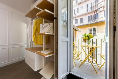 a small dressing room with a balcony with a table at Domus Gabriella - Roman Forum Apartment in Rome
