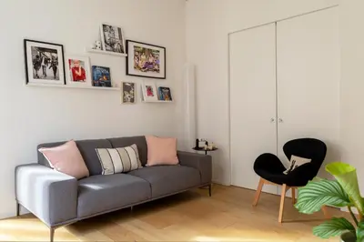 a living room with a gray couch and a black chair at Colosseum - Diana's Design Apartment in Rome