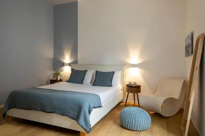 a small bedroom with a bed and a chair at Colosseum - Diana's Design Apartment in Rome